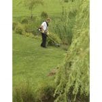 A man using a Honda UMR435 LE 35cc Loop Handle Backpack Petrol Brushcutter