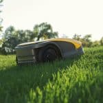 STIGA A 1500 autonomous mower moving across a sunlit garden