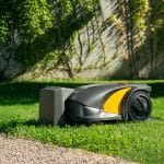 Front view of STIGA A 3000 robot mower charging on trimmed lawn